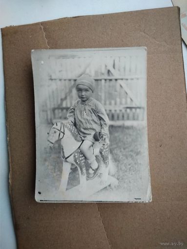 Фото девочки на игрушечной лошадке. 1950-е. 7х11 см