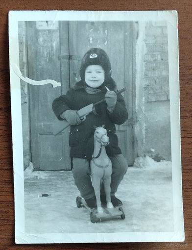 Фото мальчика с игрушечными лошадкой и автоматом. 8х11 см